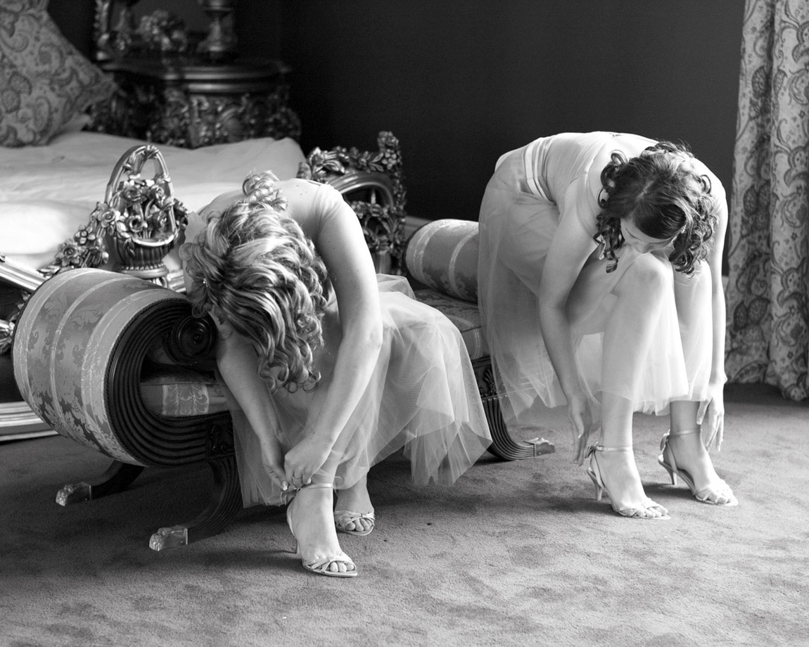 Bridesmaids sat on a chaise in the bridal suite at Allerton Castle in Yorkshire. Monochrome timeless and unedited real moments