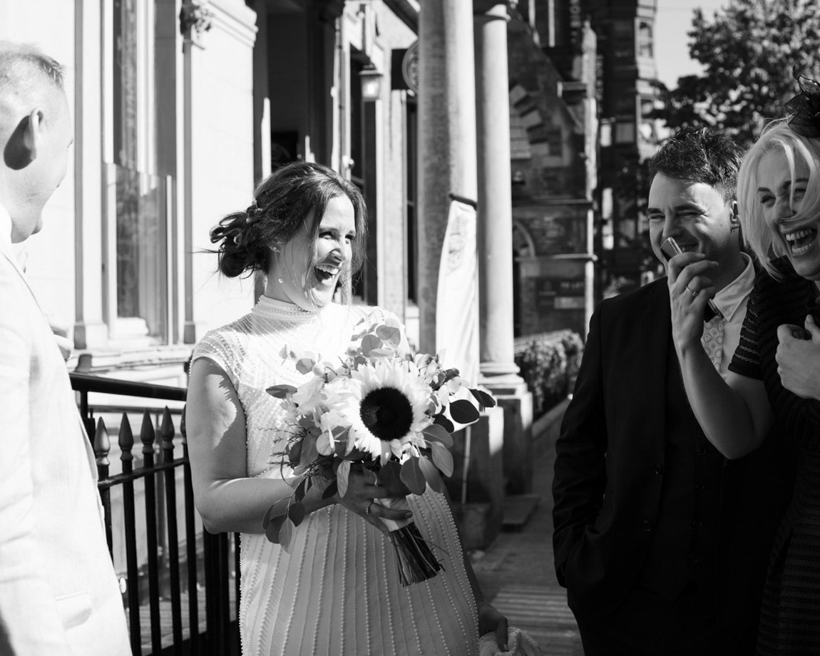 Leeds wedding photography - Gemma in fits of laughter outside the Lost and Found Leeds Club, Candid moments captured by Tim Christian Jones.