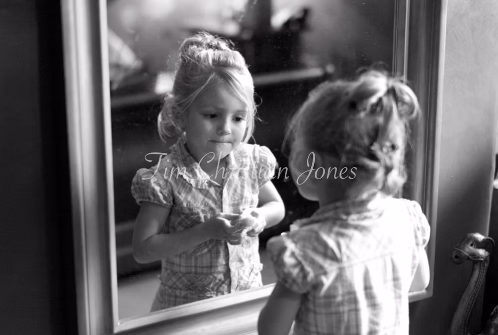 Bride's daughter putting on makeup by the mirror