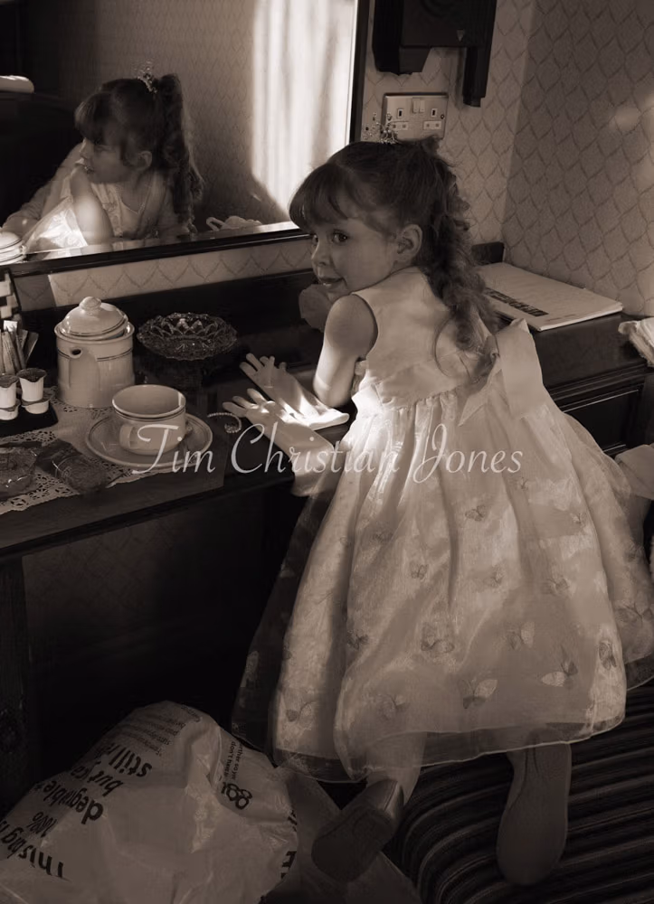 Little bridesmaid by the mirror in sepia tone