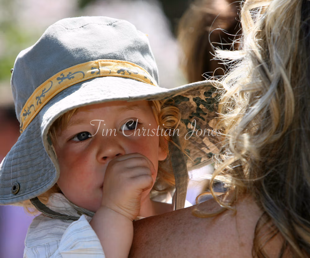 Bride holding her young son in a rose garden wedding reception