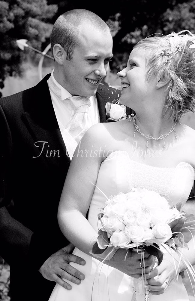 Candid black and white couple portrait &mdash; natural smiles shared in a quiet unposed moment.