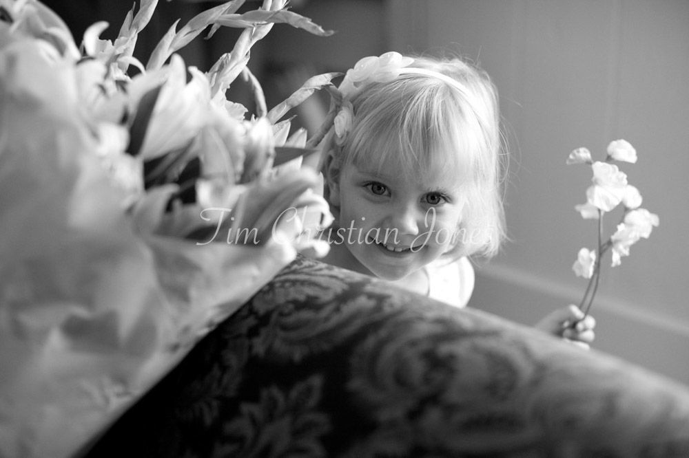 Bridesmaid peeps from the sofa holding her wedding flowers