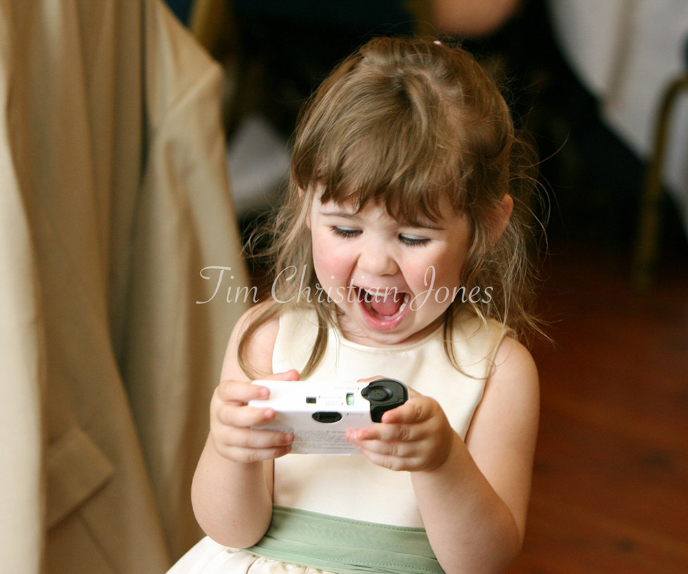 Bridesmaid laughing doing a selfie with a single use camera