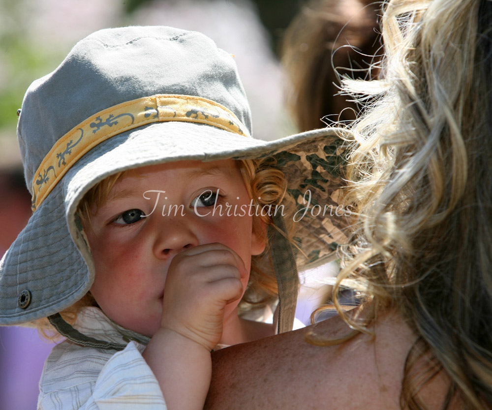 Bride holding her young son in a rose garden wedding reception