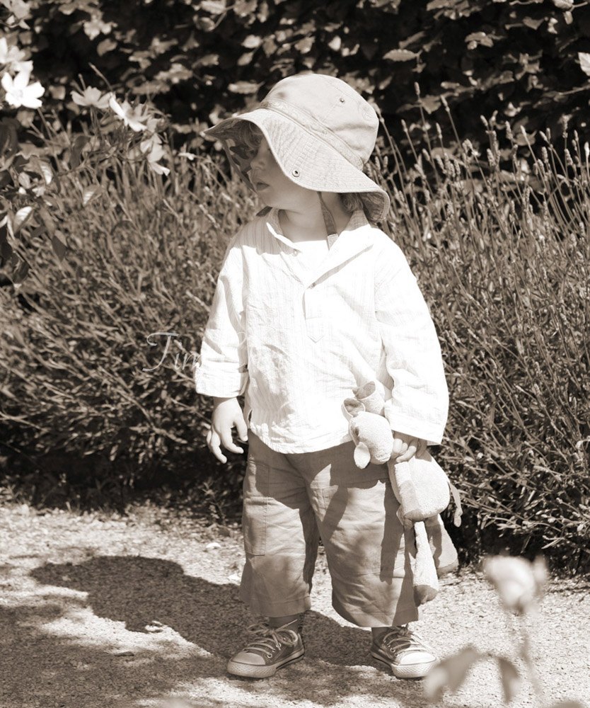Bride's son in sepia tone looking lost holding his toy