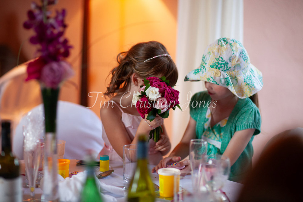 Bridesmaid holds her wedding bouquet chatting with a friend during the wedding breakfast