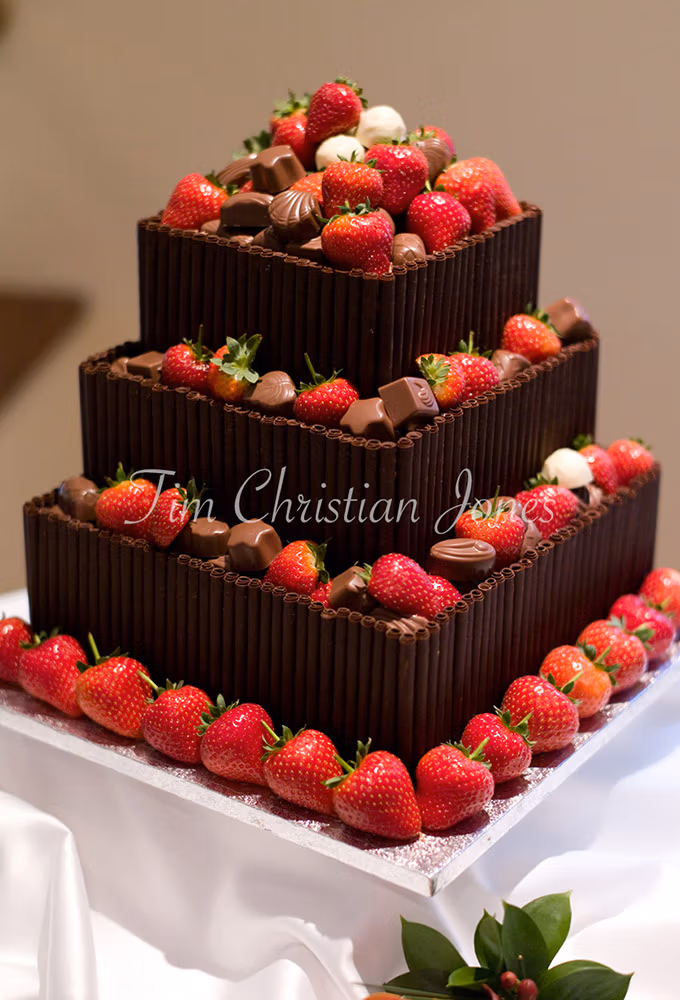 Chocolate wedding cake decorated with fresh strawberries and posh chocolates photographed by a Leeds-based wedding photographer