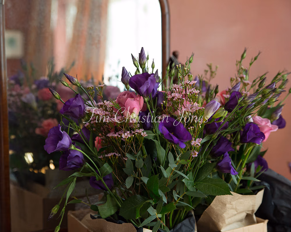 An autumnal wedding in Yorkshire - the bride's bouquet in a silver bin by an old mirror in a Rustic Wedding Venue near Leeds