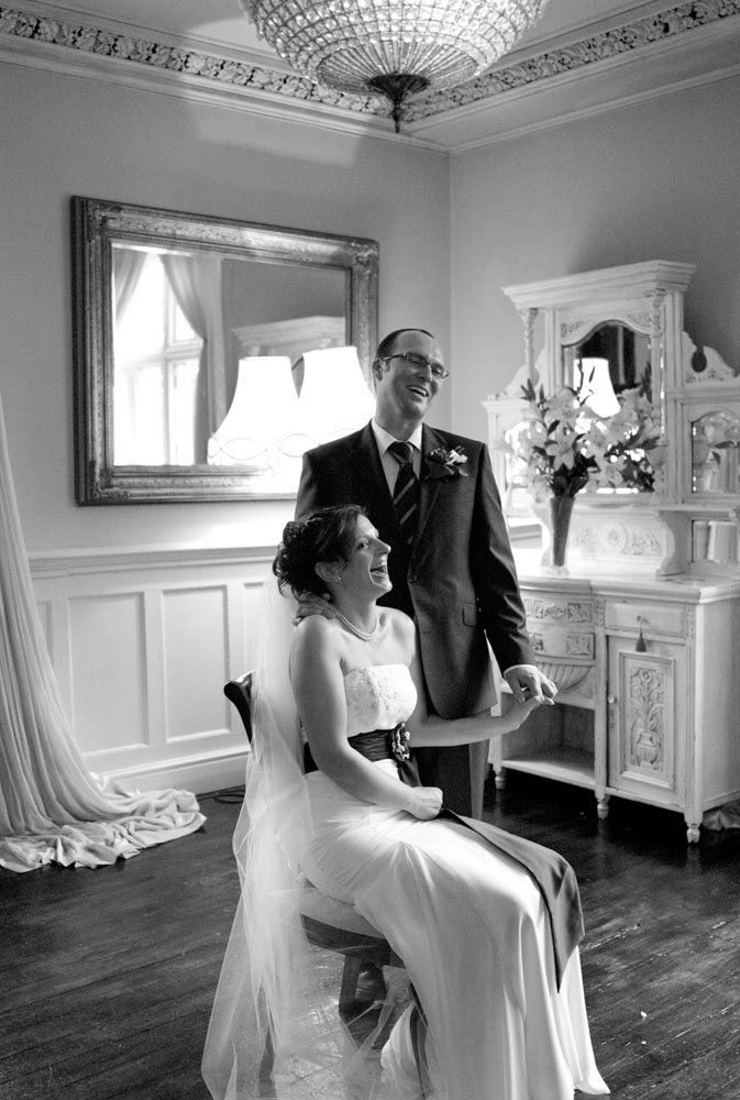 Julie & Pat share a relaxed monochrome couple portrait in the light-filled rooms at Woodborough Hall, smiling naturally together during their September wedding.