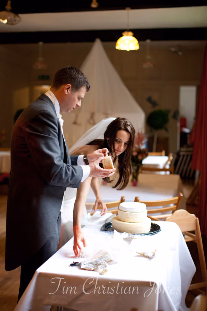 Lowri and Tim arranging their real cheese wedding cake at the Temple of Apollo
