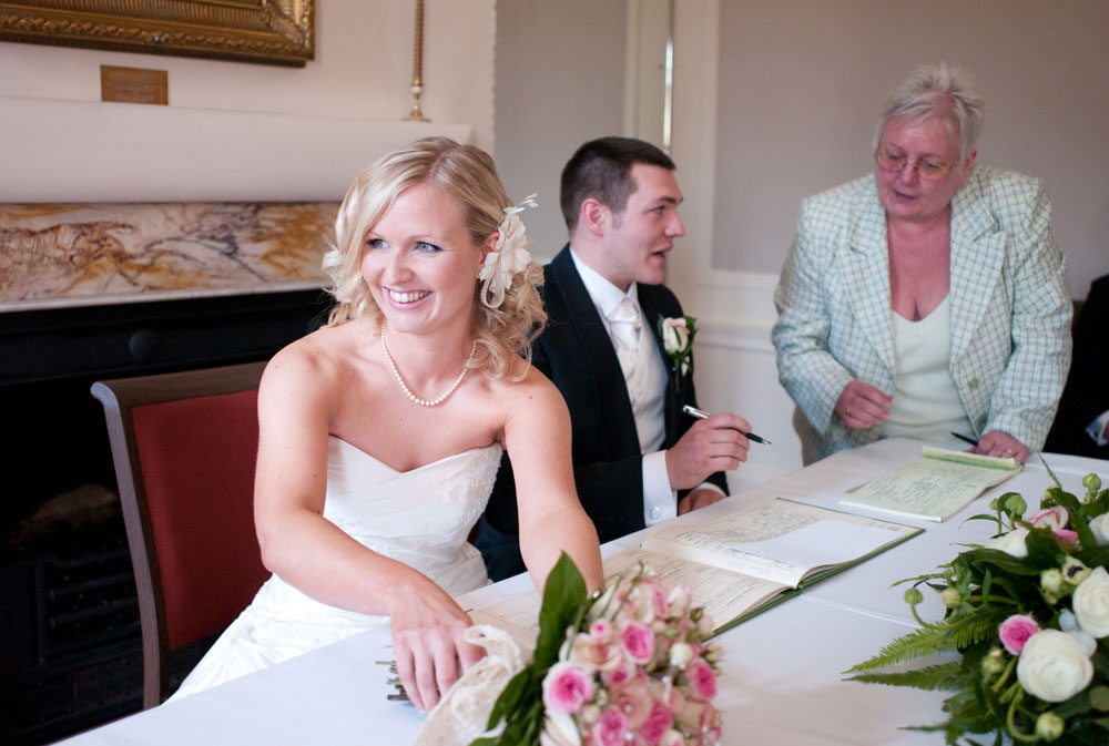 Dani and Scott signing the wedding register at their Hoyle Court Wedding