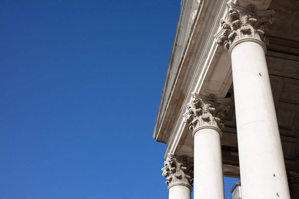 The white columns of Leeds Civic Hall stand against a clear blue Yorkshire sky