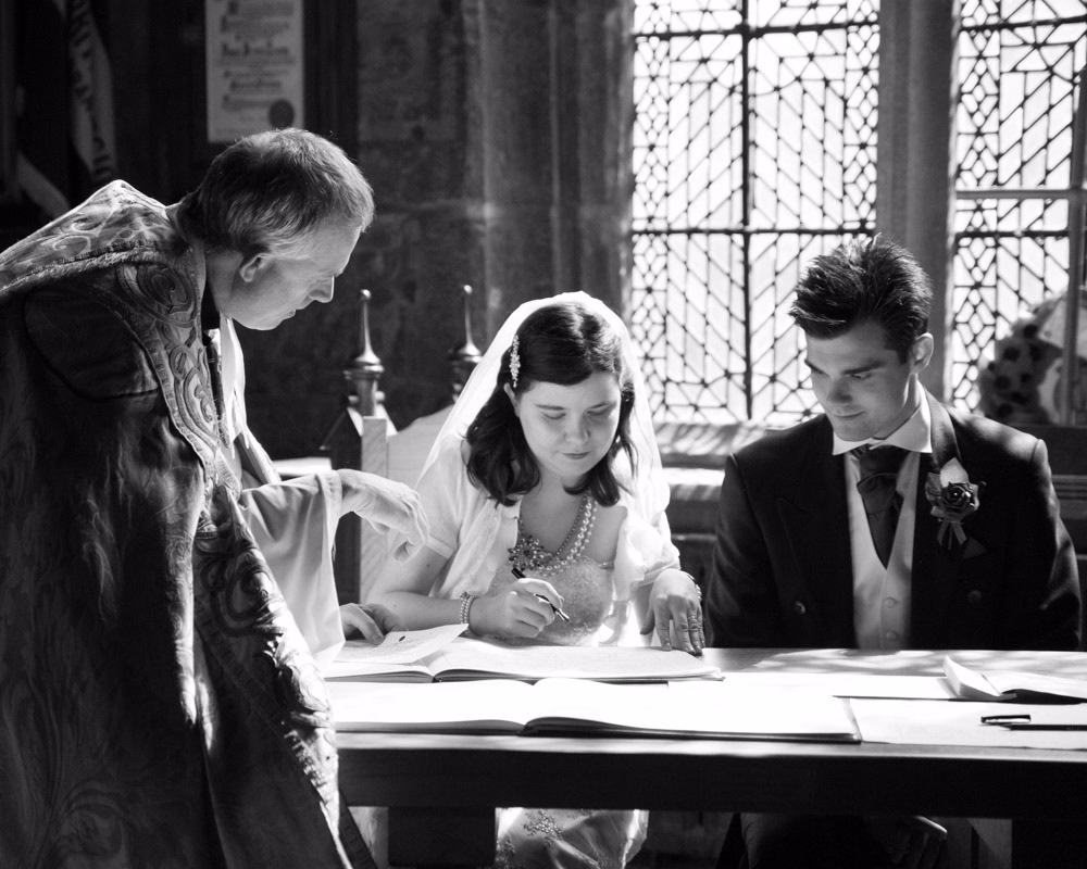Signing the wedding register in monochrome - An April wedding at Halifax Minster captured by a Leeds wedding photographer - Claire and Tom's wedding story that was truly an adventure in Halifax.