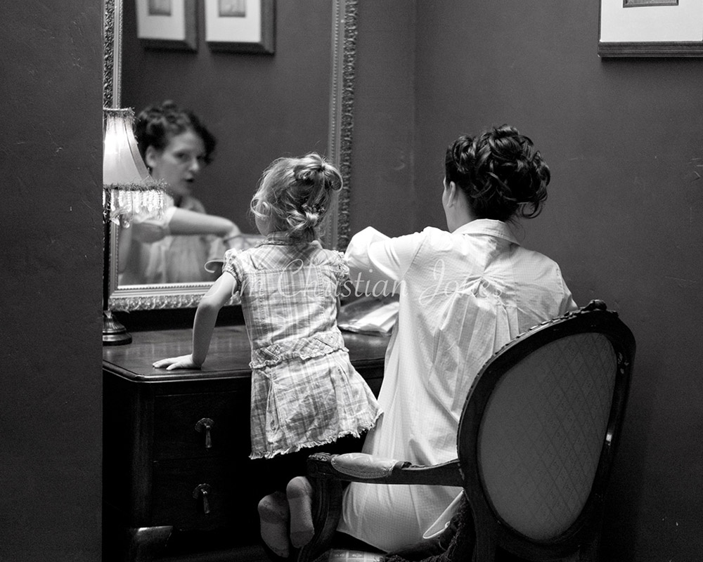 A beautiful moment during morning preparation - the bride and her little daughter at the dressing table mirror sharing a self makeup moment. Captured by an unobtrusive Leeds wedding photographer.