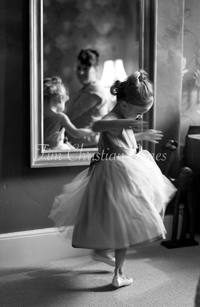 Motion captured using slower shutter speed - little bridesmaid twirls by the mirror in the bridal suite - captured by an experienced Leeds wedding photographer