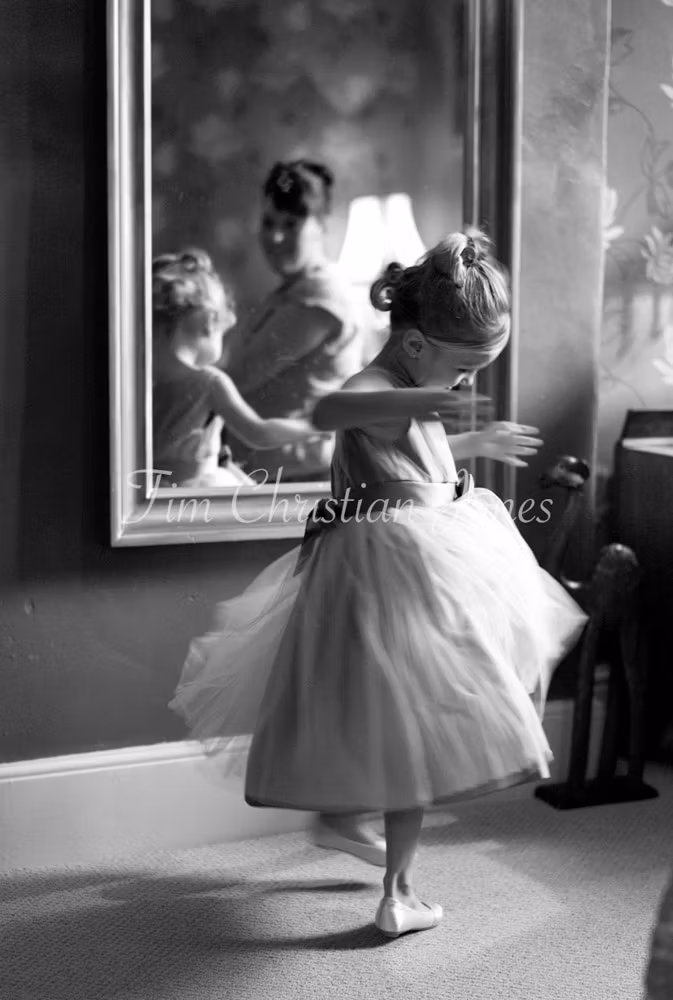 A black and white image of the bridesmaid twirling, dress swirling in soft motion blur.