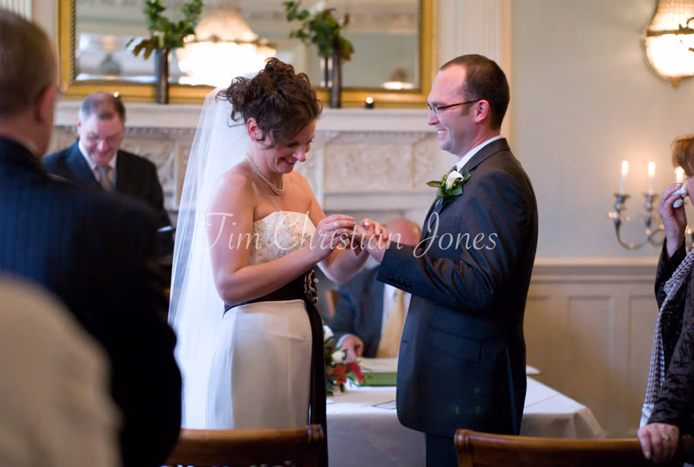 Julie gently slides the wedding ring onto Pat’s finger as they share a smile during the ceremony.