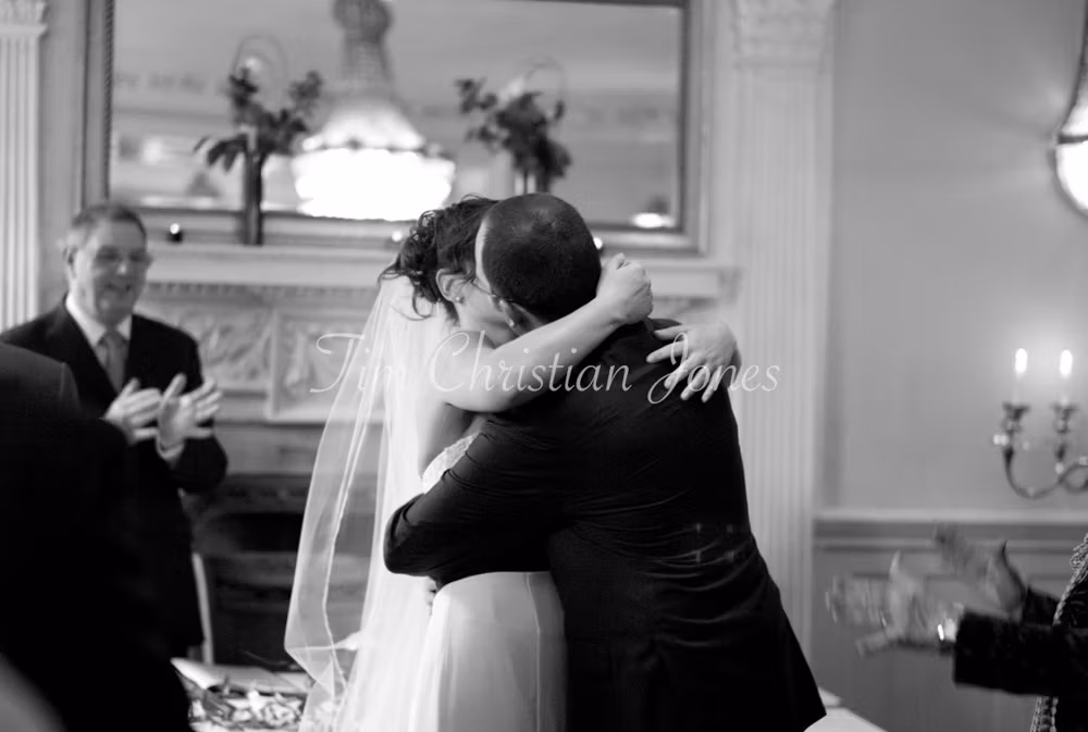 In black and white, the couple embrace tightly, laughter spilling from their kiss.