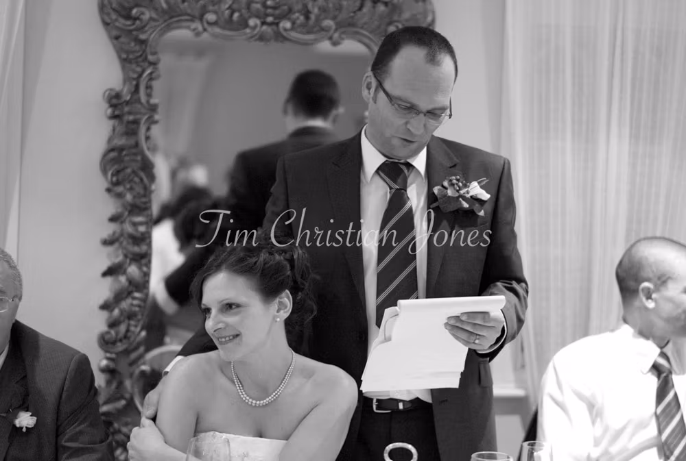 Pat speaks while Julie leans in beside him, their closeness unmistakable.