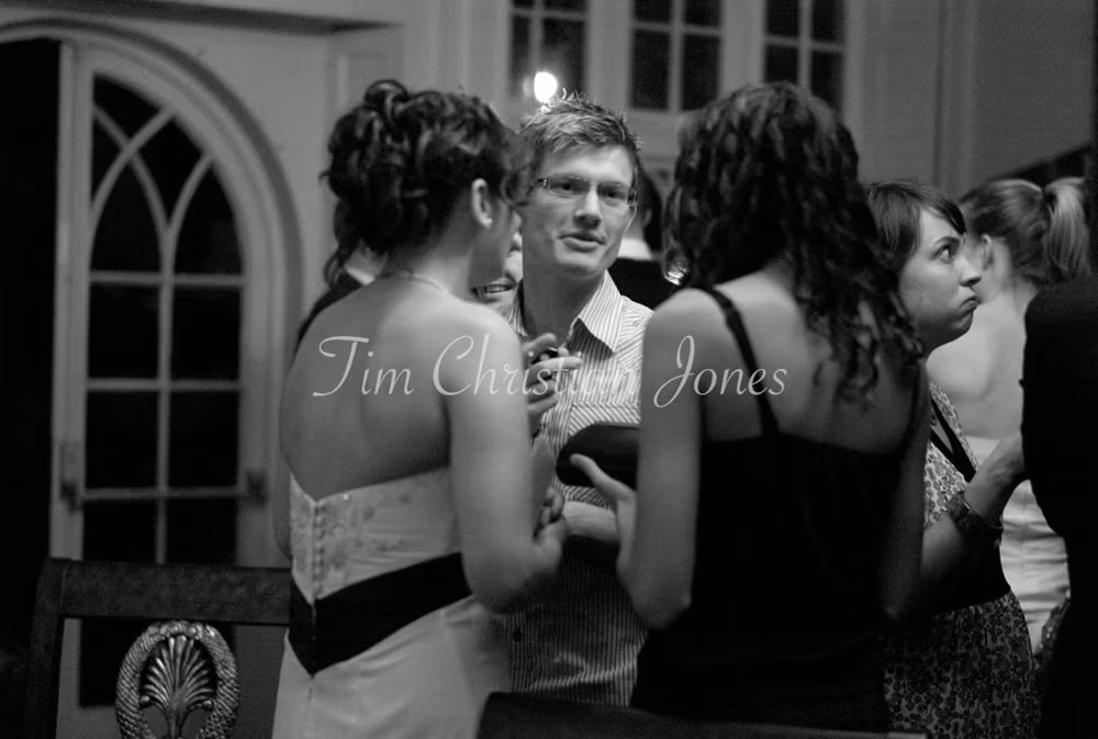 The bride warmly greets evening guests, chatting as they join the celebration.