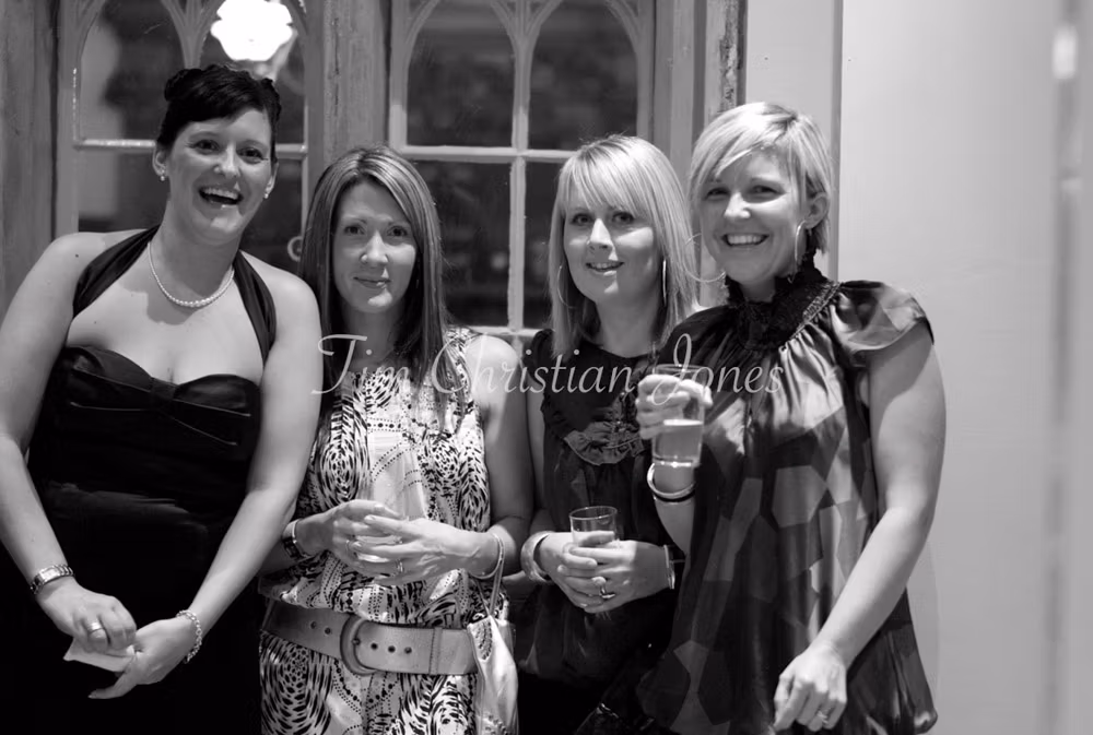 The bride’s sister laughs with three close friends in a candid group moment.