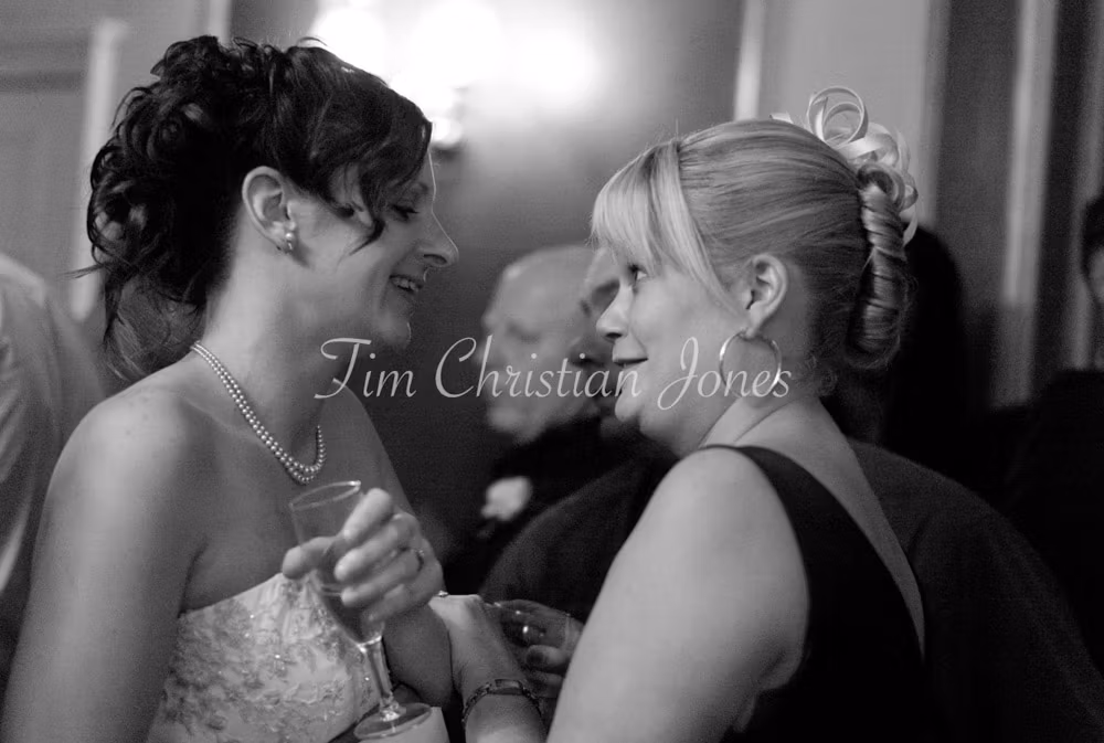 A quiet moment as Julie leans in to chat with a close friend during the reception.