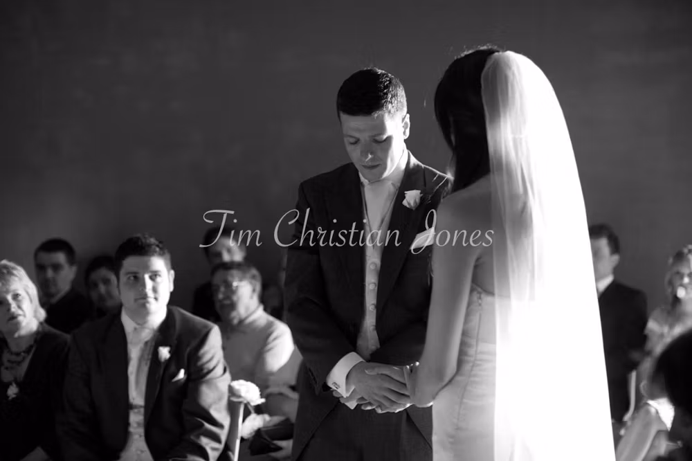 Bride and groom share an emotional moment in black and white during their wedding vows