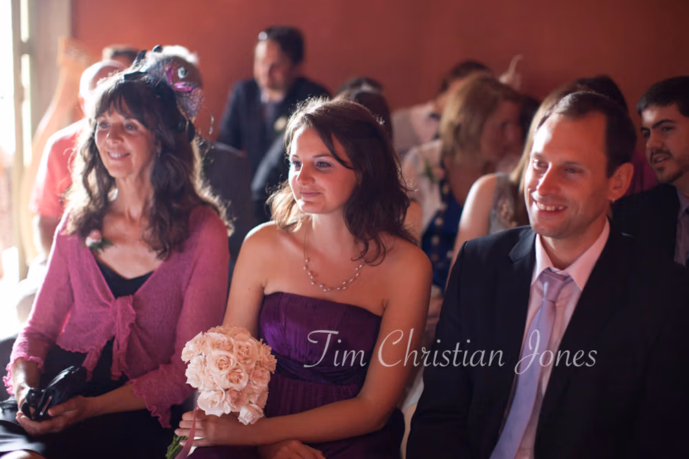 Guests seated in the front row smiling during the ceremony