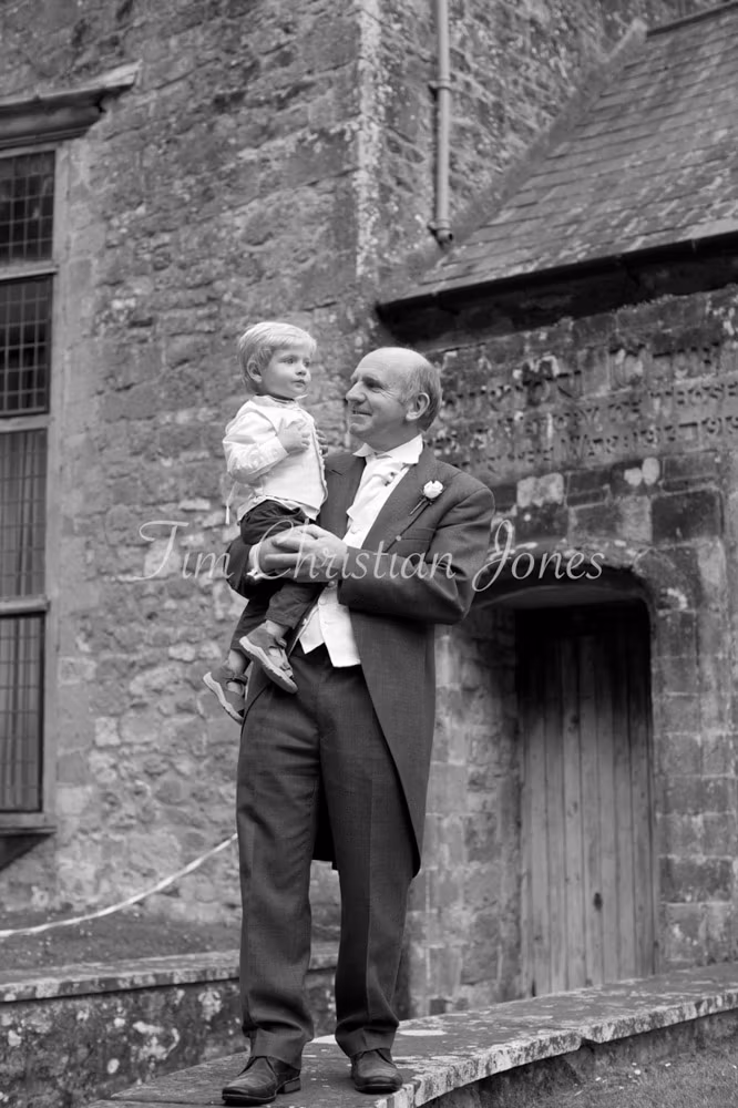 Black and white photo of Grandpa holding the couple’s young so