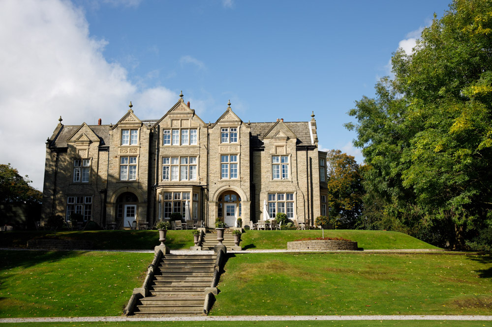 The Woodlands Hotel in Leeds with blue skies and trees seen from the garden steps