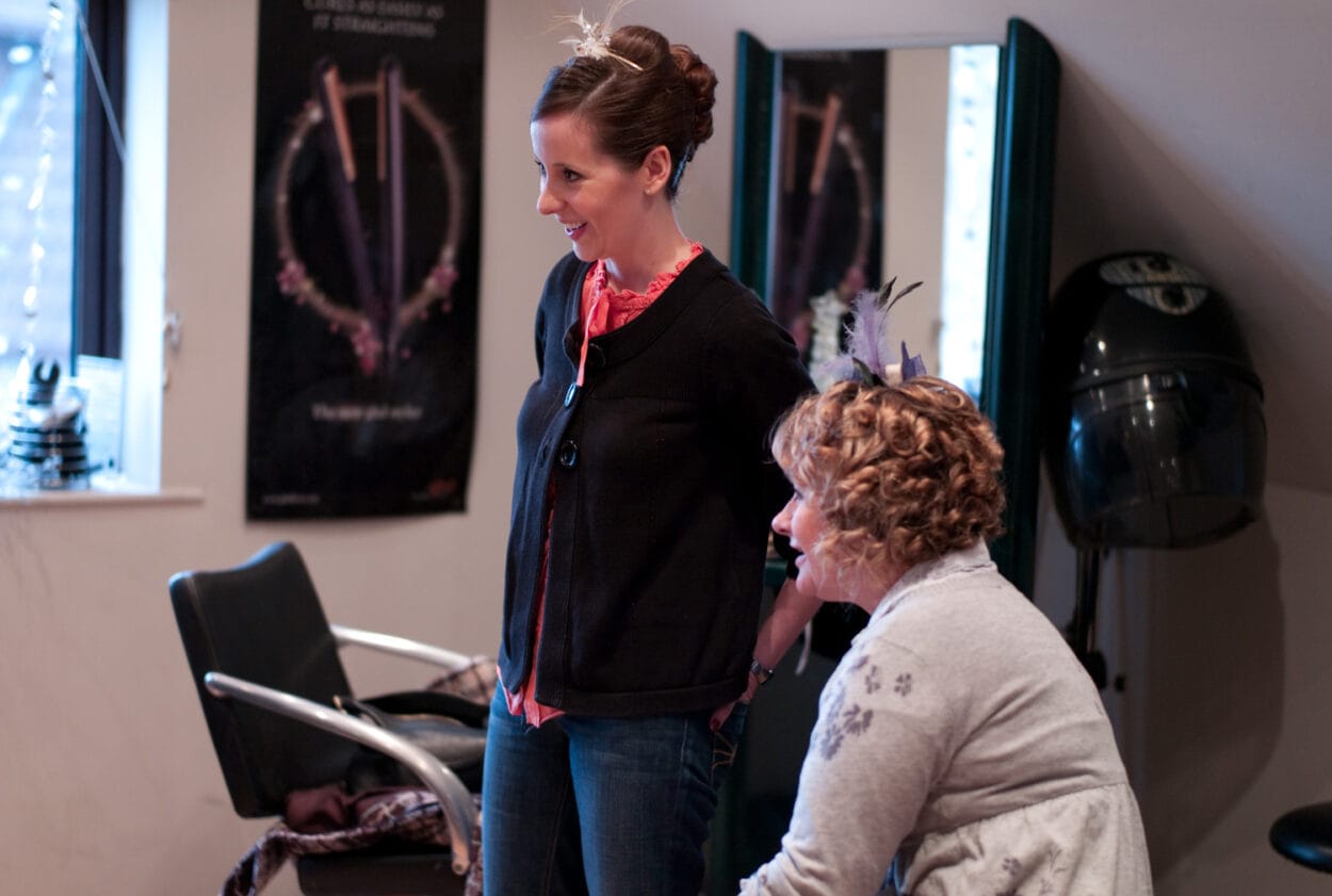 Emelie stands beside her mum smiling toward her sister.