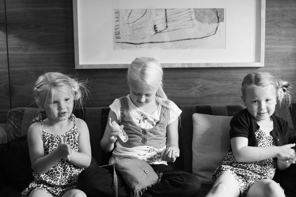 Black and white photograph of the bridesmaids wiping their hands with hand sanitiser.