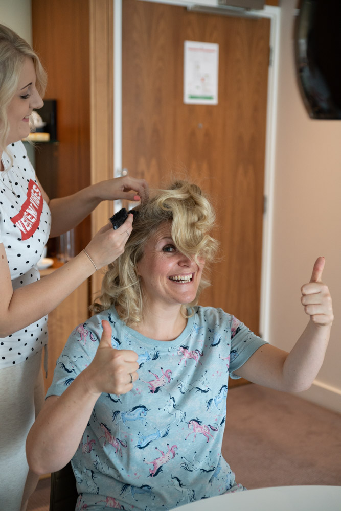 Clare giving a thumbs up while getting her hair styled