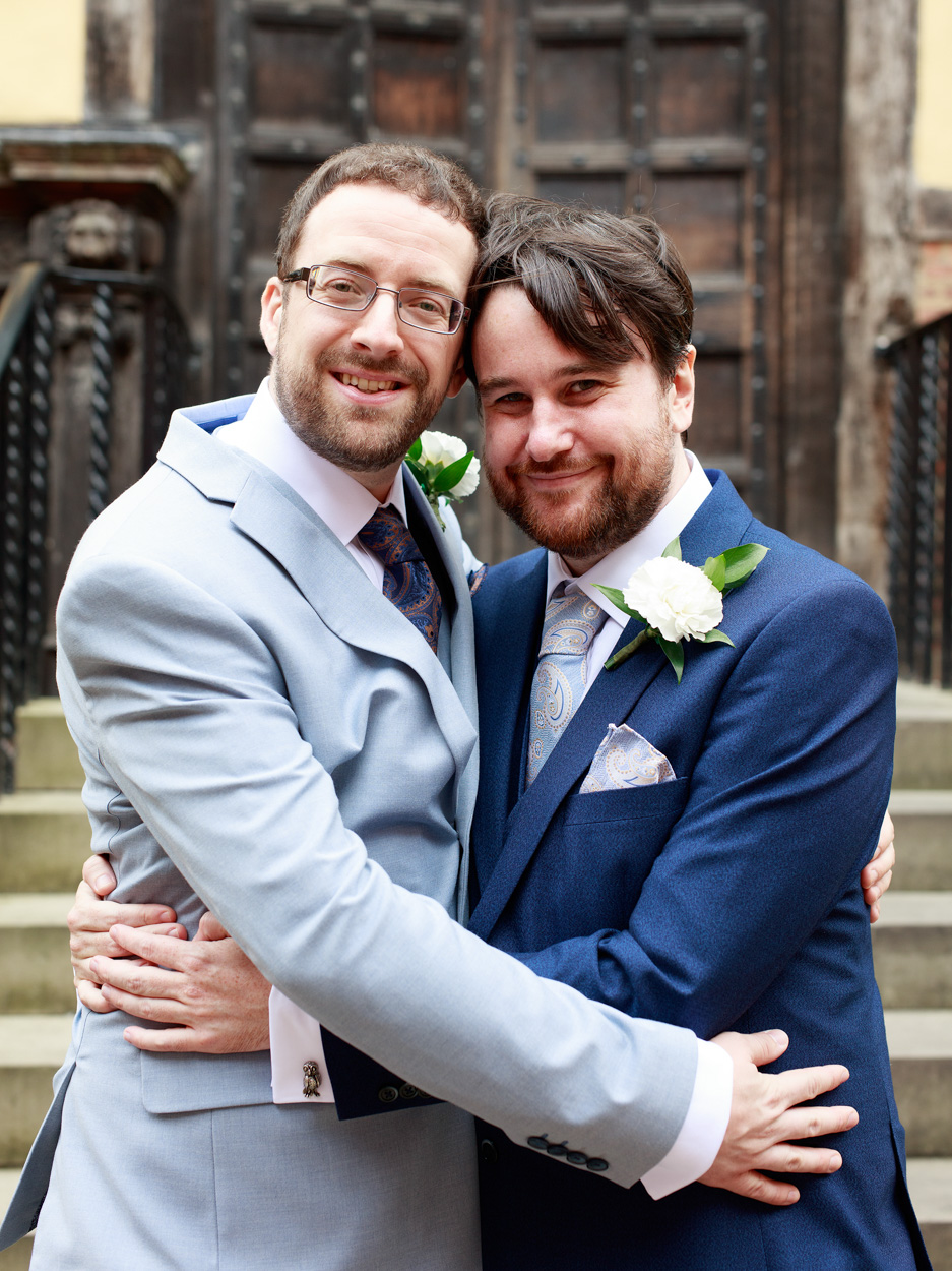 Chris and David walk arm in arm before the ceremony, smiling gently.
