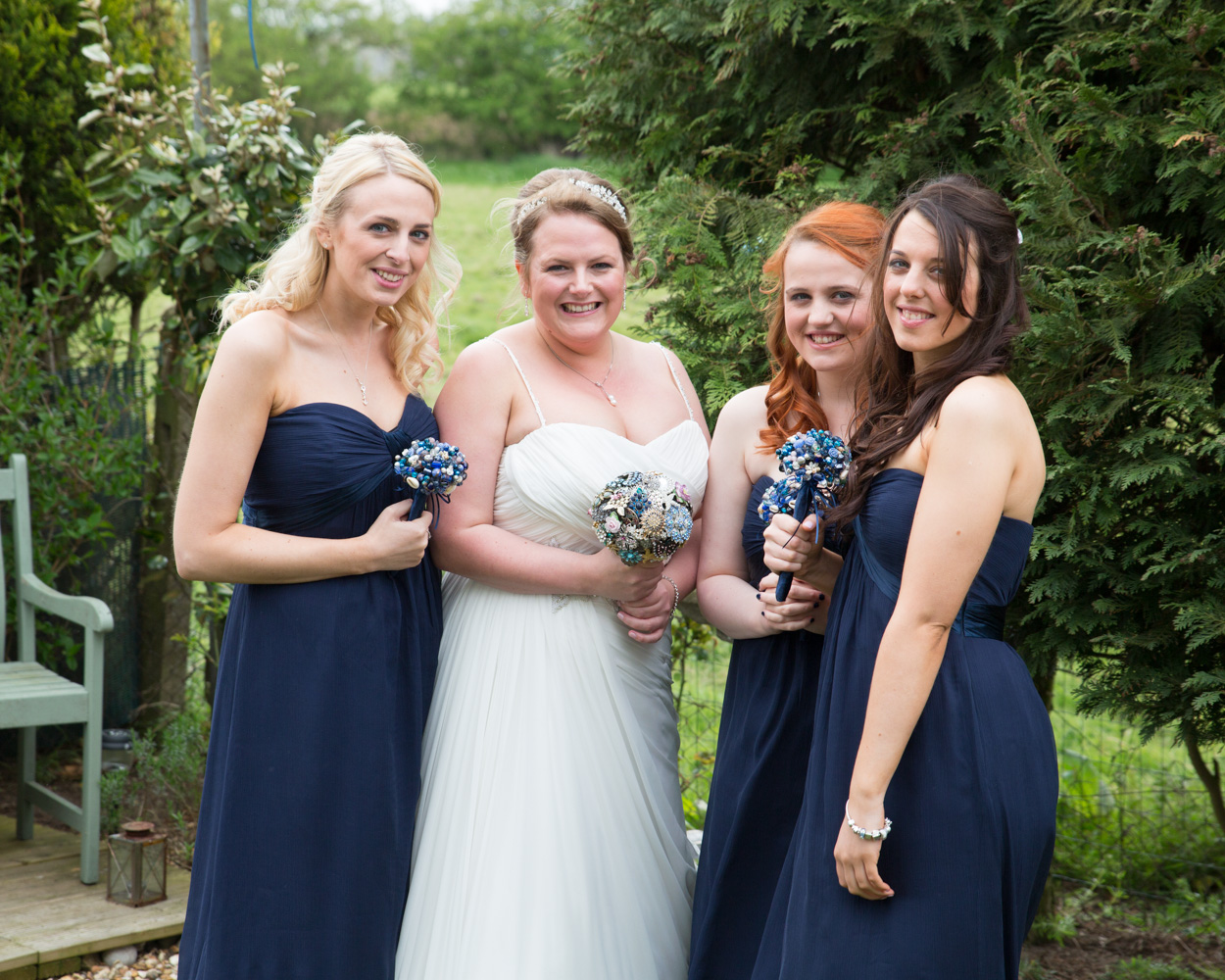 Bride smiling with her bridesmaids in the garden before her wedding at Scarborough Spa, relaxed and natural.