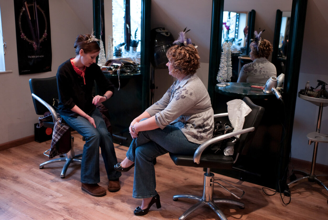 Emelie checks the time on her watch while sitting opposite her mum.