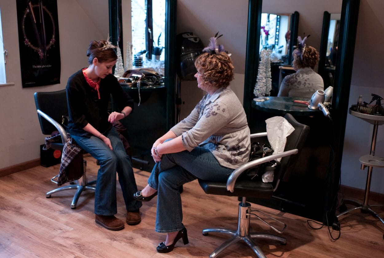 Emelie checks the time on her watch while sitting opposite her mum.
