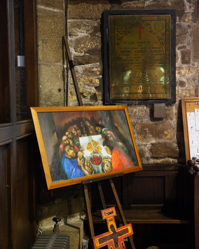 A brass plaque and painting of The Last Supper inside Halifax Minster.