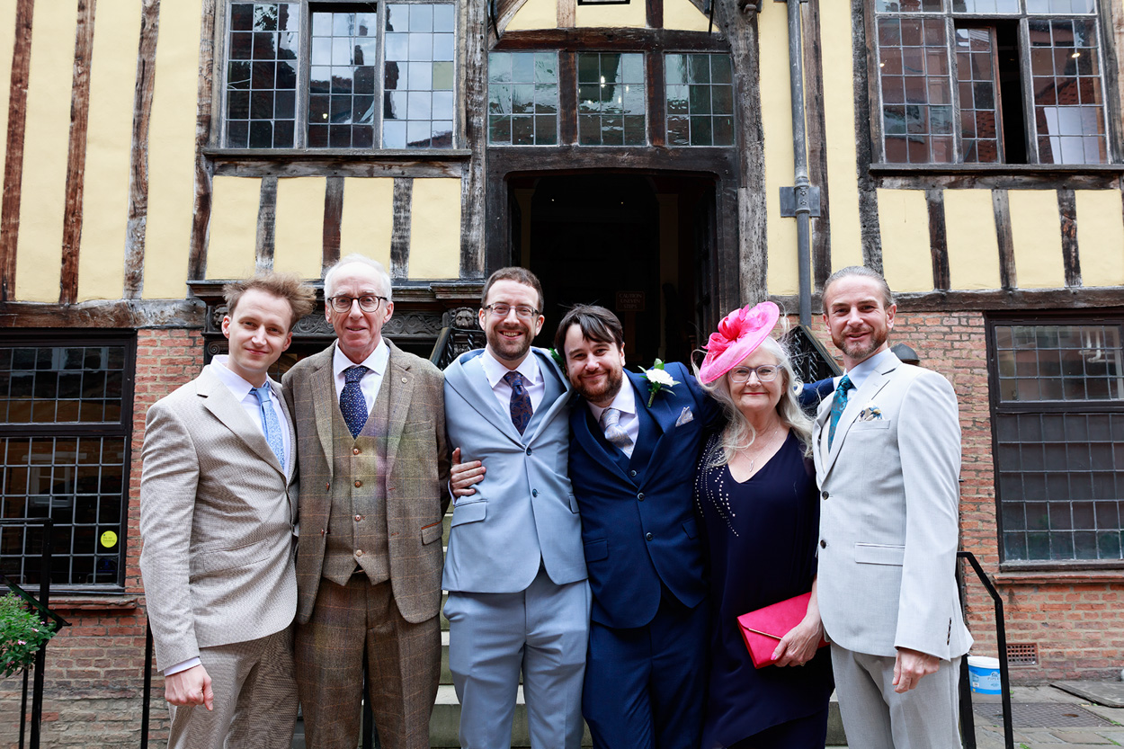 Family portrait of Chris and David with parents and brothers inside Merchant Adventurers’ Hall.