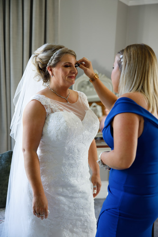 Tracy having final makeup touches applied on her wedding morning