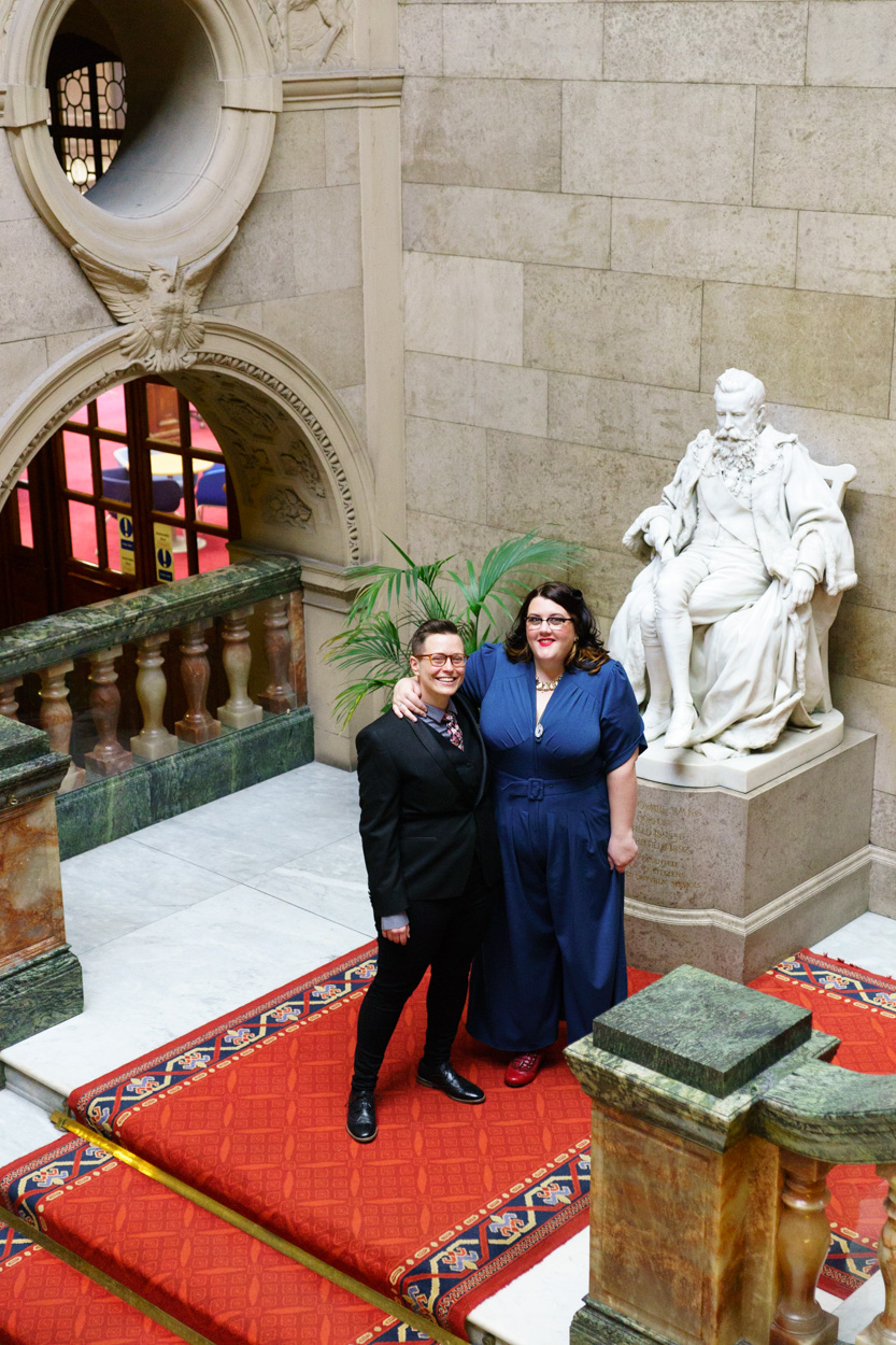 Couple portrait on the red carpeted stairs at Sheffield Town Hall before the ceremony
