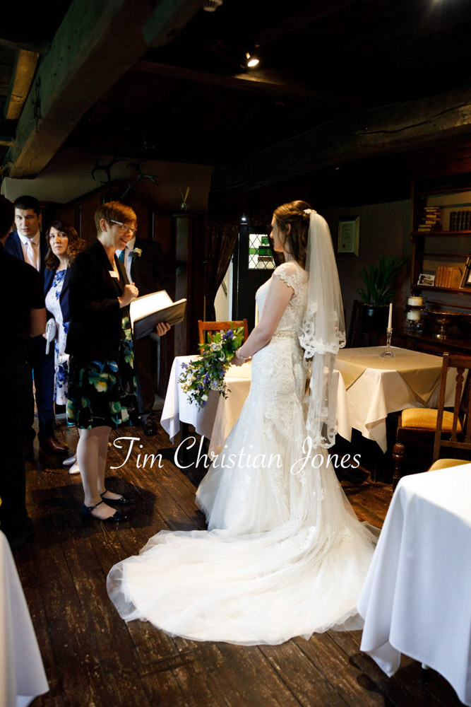 Natural wedding photography of bride with registrar at The Priests House