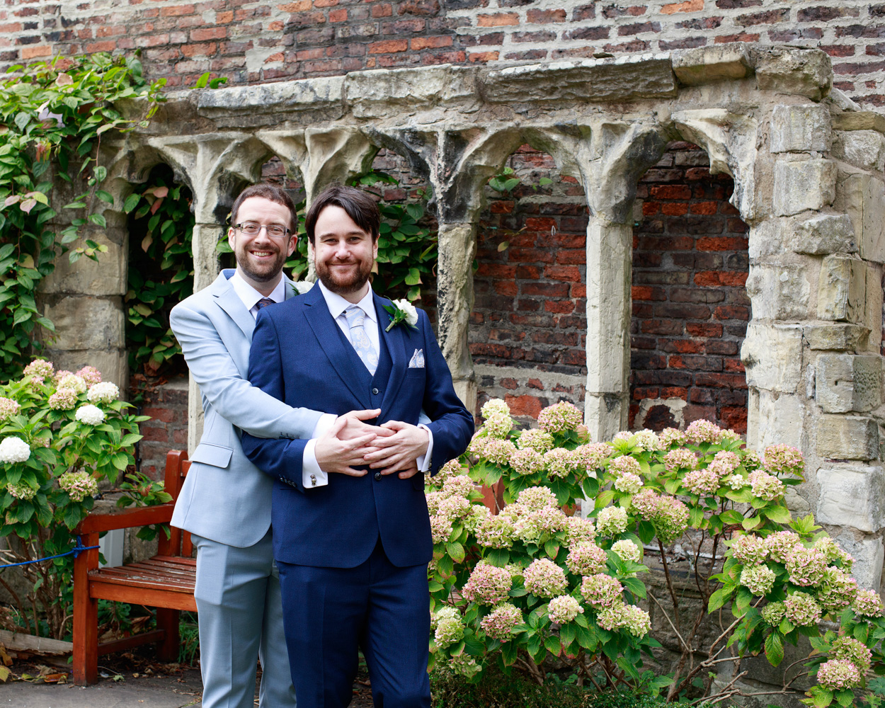 Chris and David share a hug beneath the stone arches near the church windows at Merchant Adventurers’ Hall.