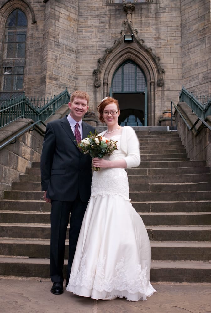 Bride and father smiling on steps of St George’s Church Leeds before entering.