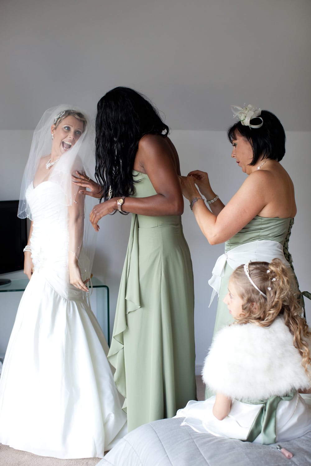 Bride beaming as her close friend arrives during preparations.