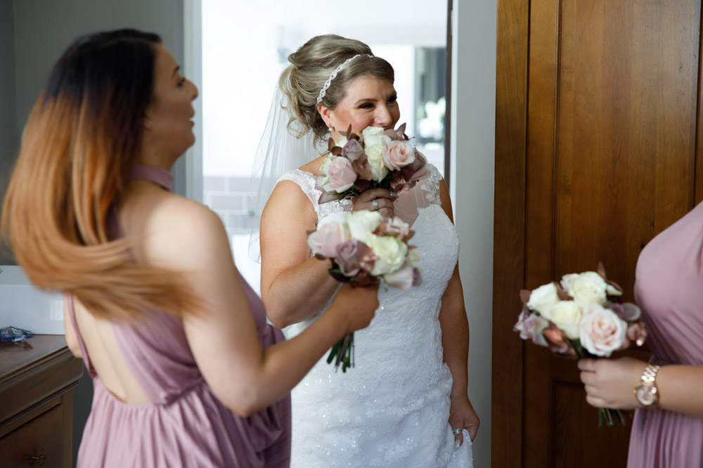Tracy laughing with her two bridesmaids in the bridal suite