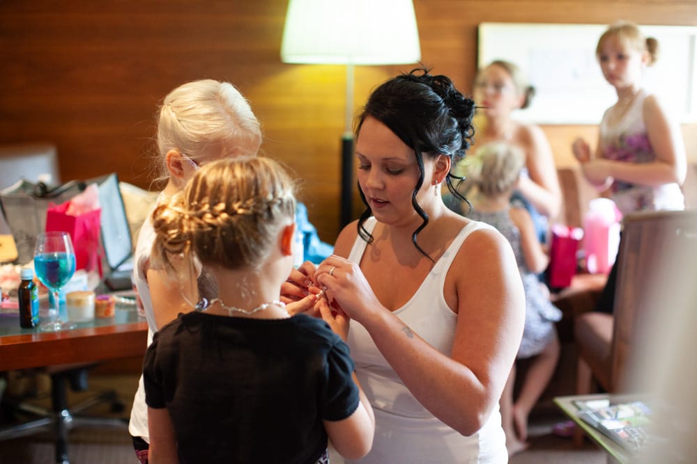 Gemma with two little bridesmaids, fastening bracelets together before the ceremony.