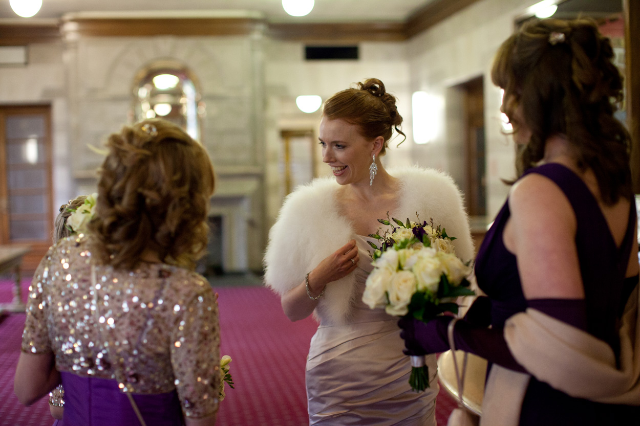 Bride and bridesmaids waiting together inside the reception area at Leeds Civic Hall.