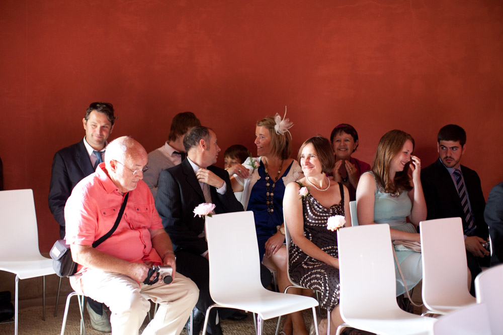 Guests seated inside the Temple of Apollo, red walls and sunlight from the open doorway